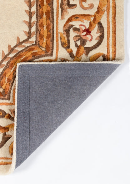 Beige oriental rug with orange-brown vine motif; blue-gray fabric backing visible at corner.