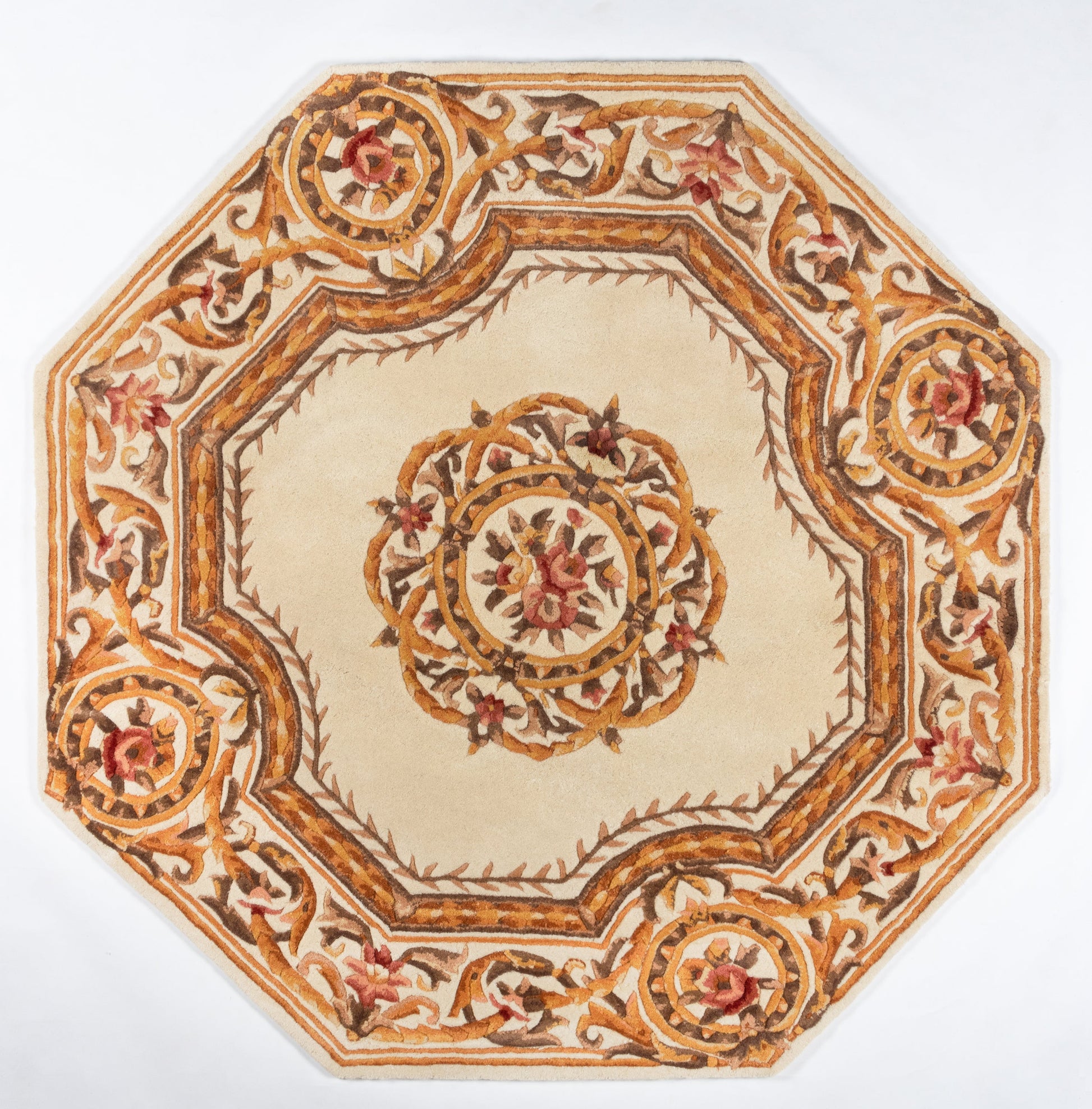 Ornate oriental-style octagonal area rug with ivory center, gold-brown borders, and red floral medallions.