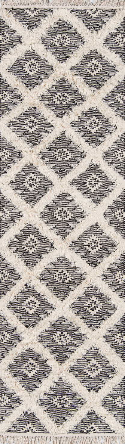 Rectangular rug with cream shag diamond lattice on dark navy background; fringed edges, geometric boho design.