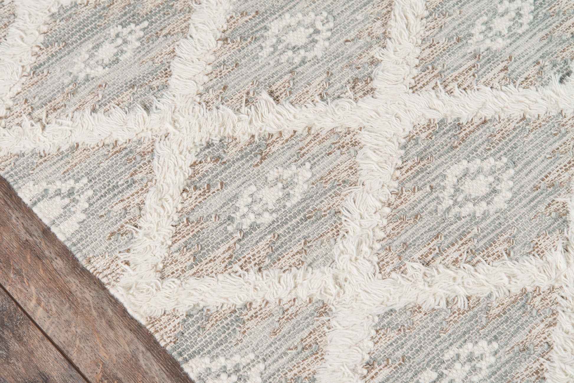 Rectangular neutral woven rug with blue-gray and beige geometric pattern and cream tufted cross stripes.