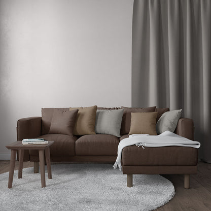 Brown fabric L-shaped sofa with chaise, beige/gray cushions, white throw, wood coffee table, gray rug in living room.