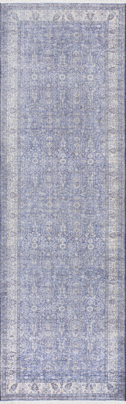 Blue distressed Persian-inspired area rug with ivory cream floral motifs and ornate border.