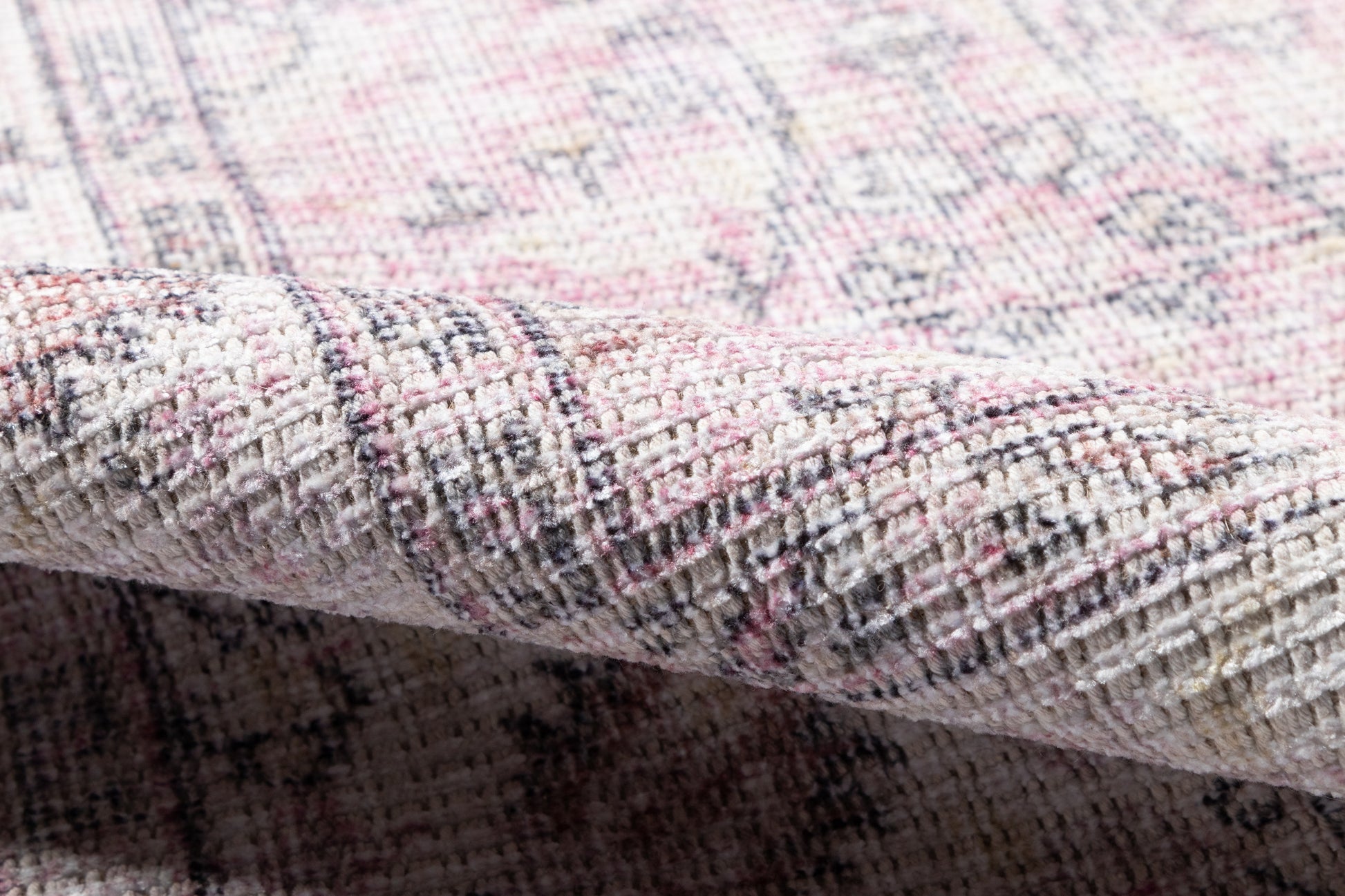 Pink, ivory & gray woven rug with geometric pattern, plush pile & rolled edge.