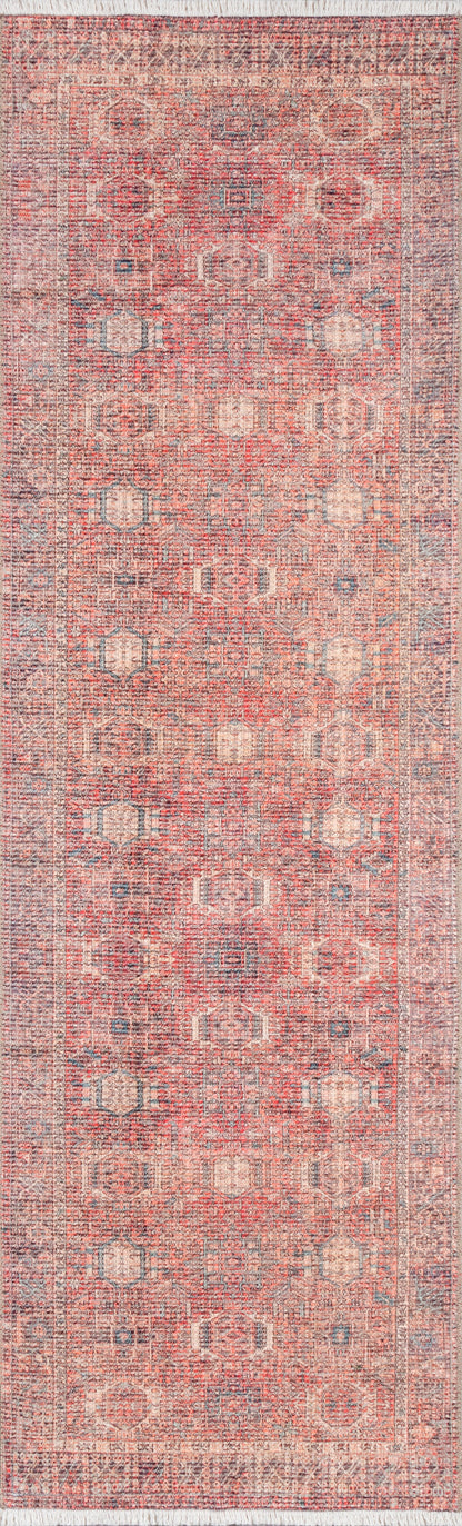 Distressed oriental rug in coral pink with pale blue geometric medallions & a muted border; fringe ends