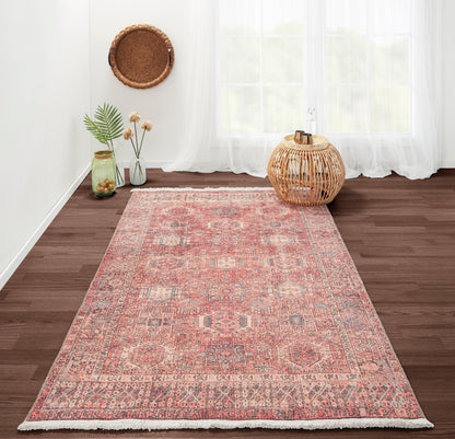 Pink and ivory vintage kilim runner rug on dark wood floor, boho decor with woven rattan lantern and glass vases.