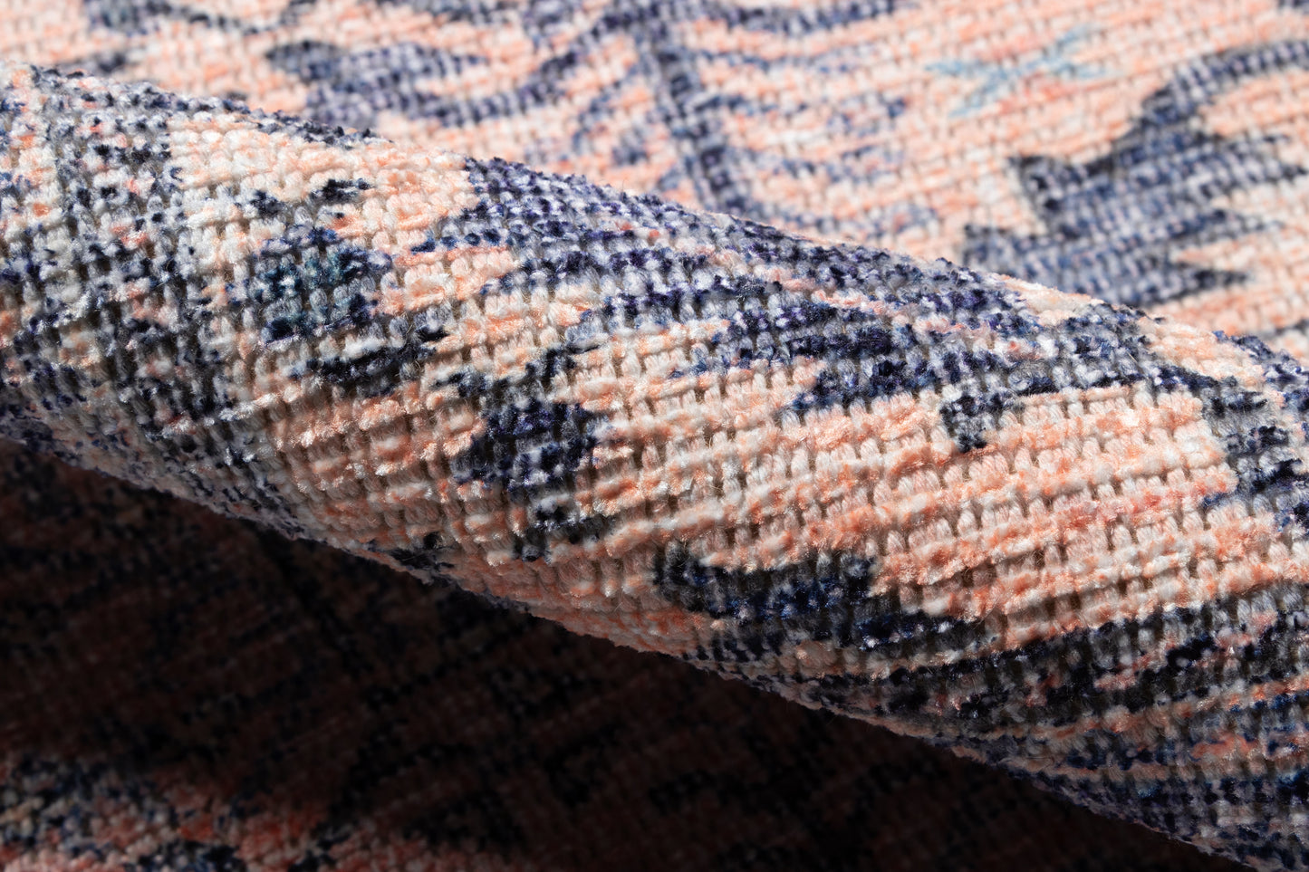 Peach, navy and cream woven rug with floral medallion pattern; close-up of plush textured pile.