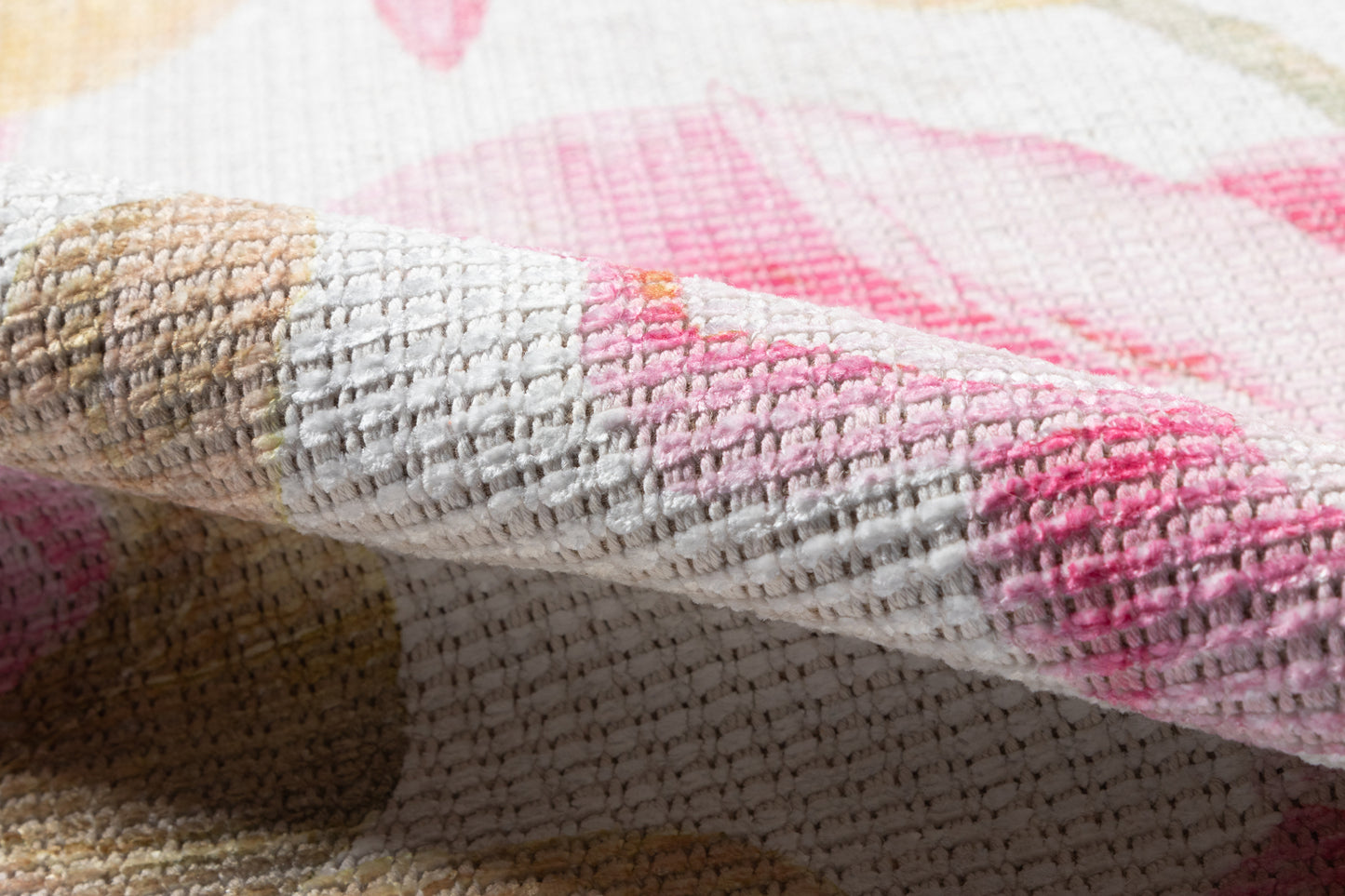 Soft woven runner rug with pink, cream and tan pattern; plush loop pile, folded corner.