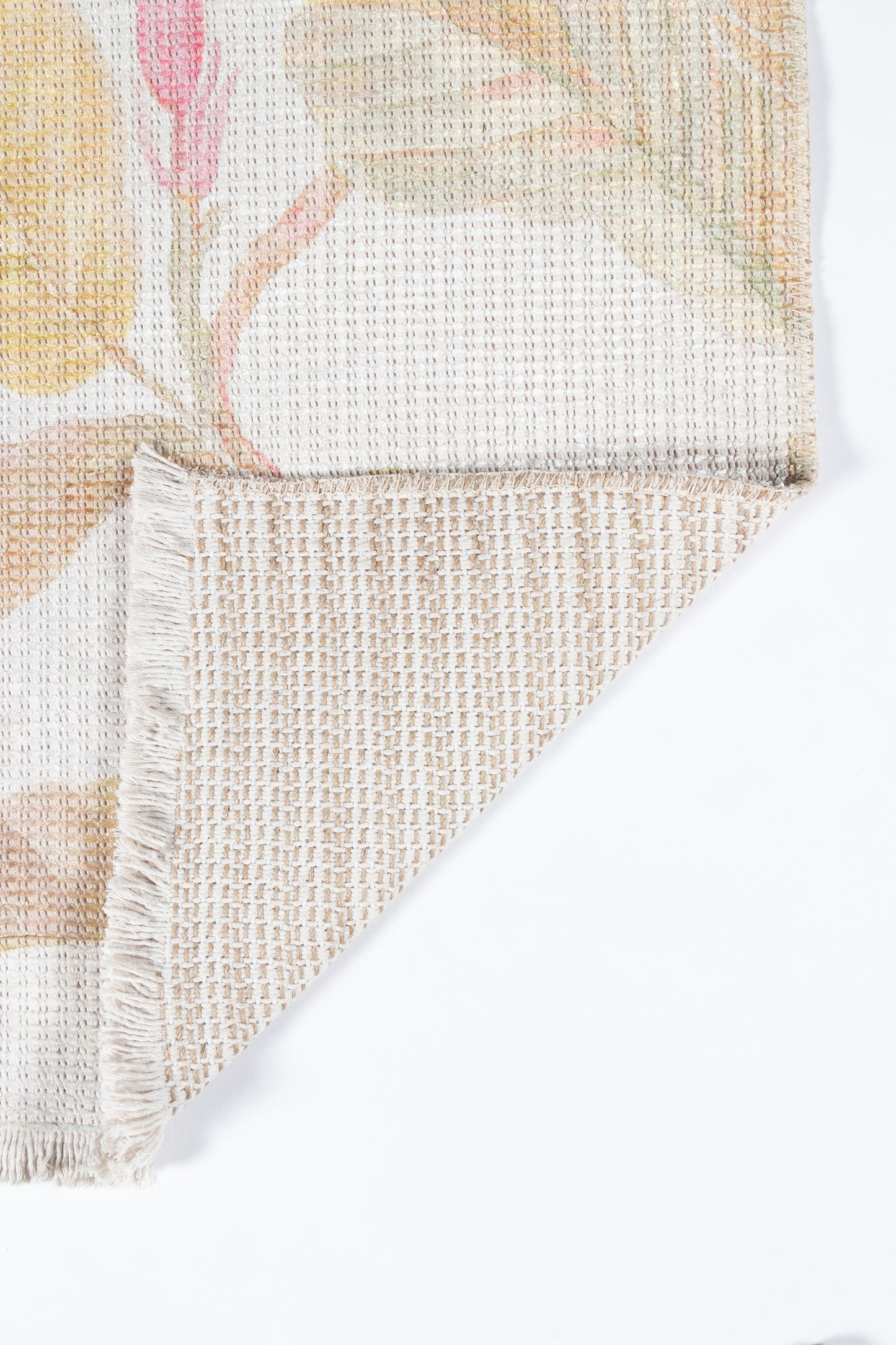 Pastel floral woven rug with beige grid back and fringed edge; soft decorative floor cover.