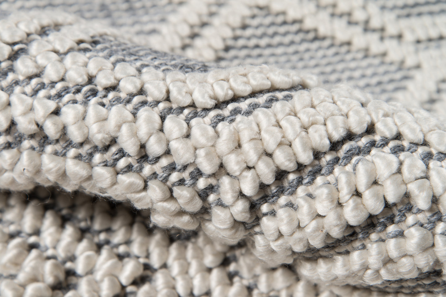 Soft gray and ivory boucle rug with chunky loop pile; woven texture for a cozy living room.