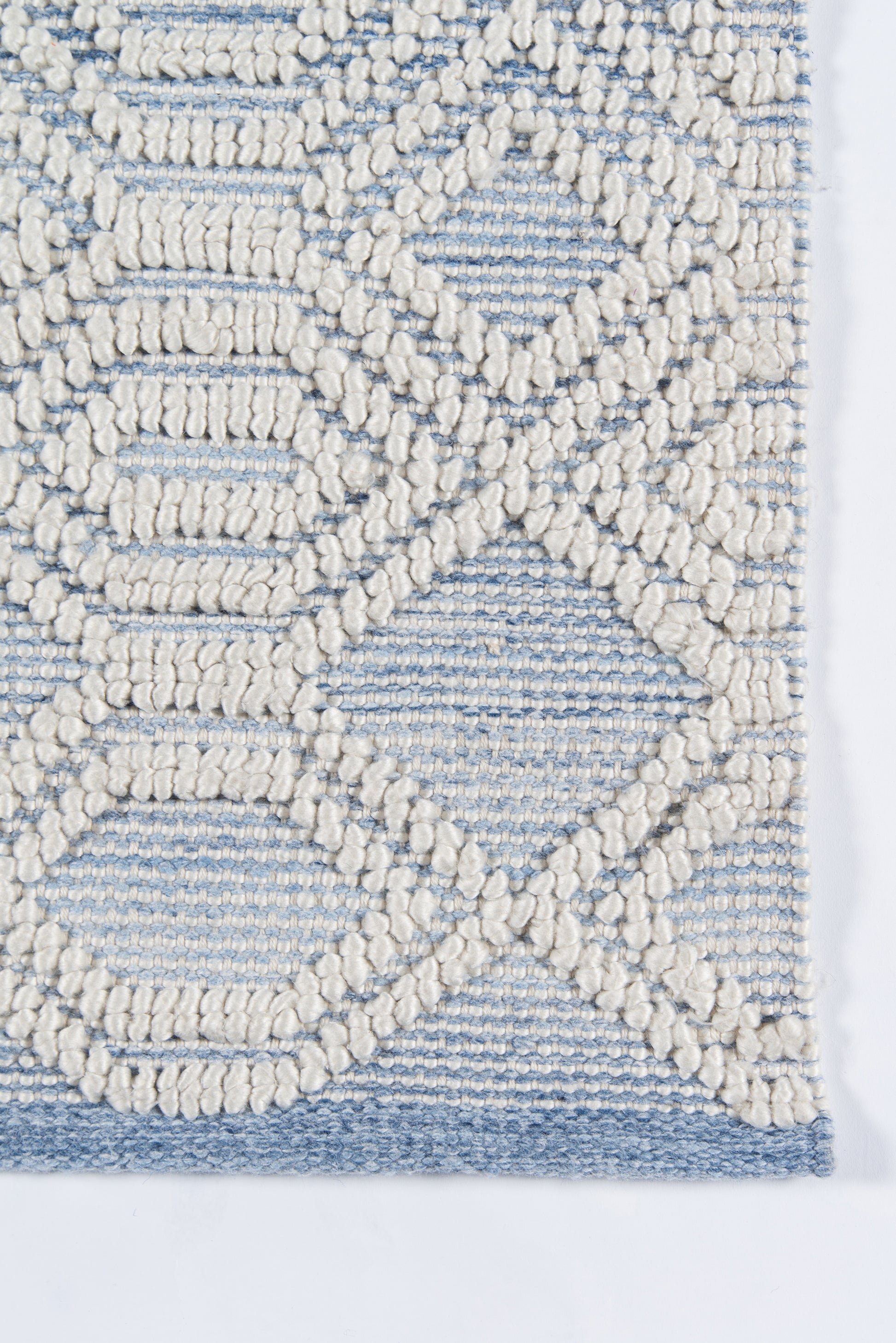 Blue and ivory geometric rug with thick boucle texture and border.