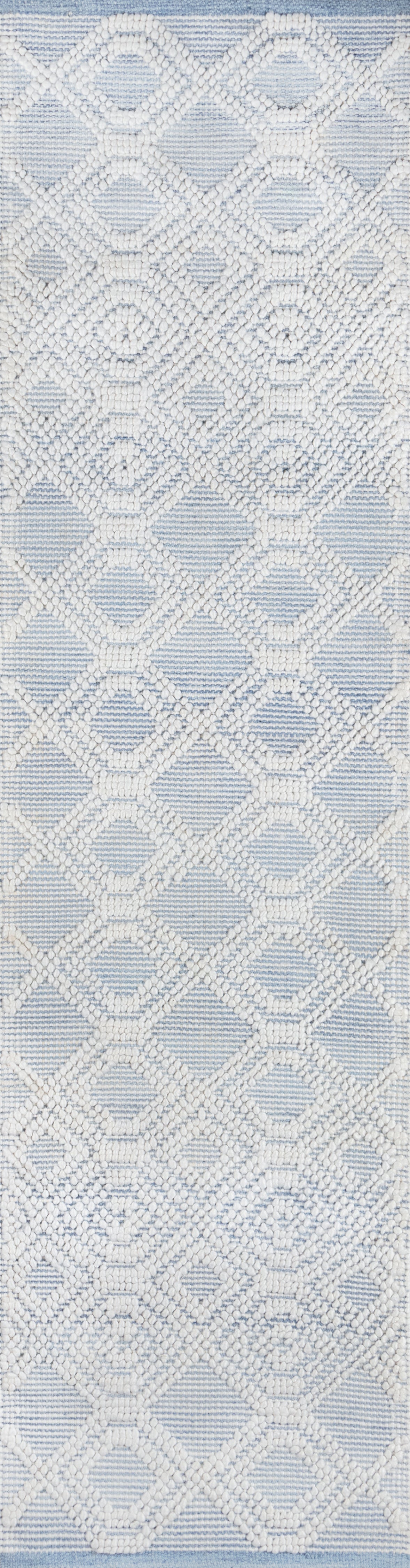 Light blue rug with white raised diamond lattice and circular motifs, a textured lace-like pattern.
