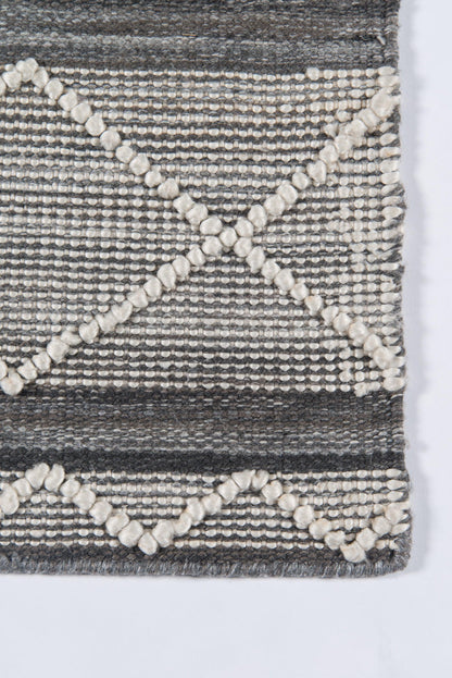 Grey woven rug with cream boucle pom-pom lines forming diamond patterns; textured rectangular rug.