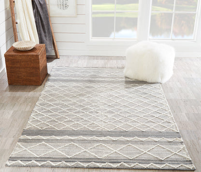 Gray and ivory woven runner rug with a diamond lattice pattern in a bright room, beside a fluffy white ottoman.