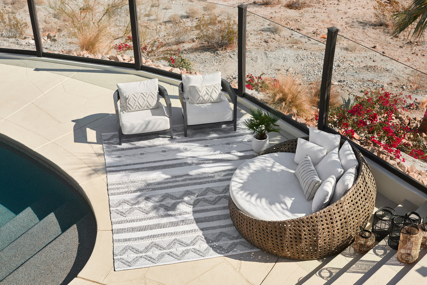 Striped outdoor rug, 2' x 3', on a poolside deck.