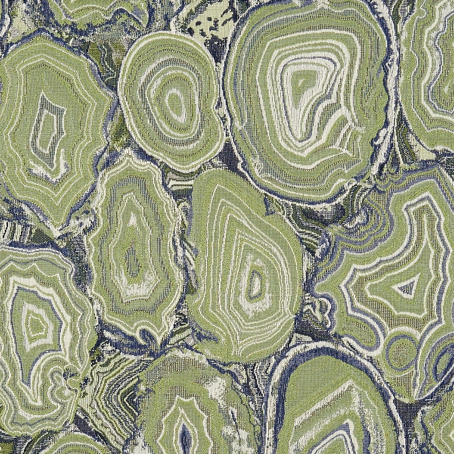 Geode-style fabric with lime green concentric rings resembling agate slices on a navy background; decorative upholstery.