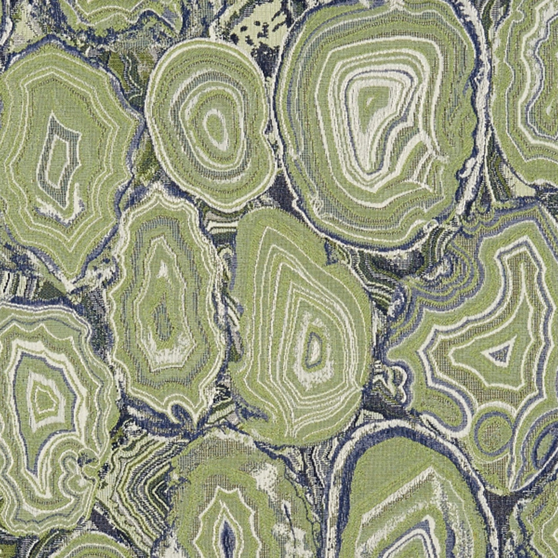Geode-style fabric with lime green concentric rings resembling agate slices on a navy background; decorative upholstery.