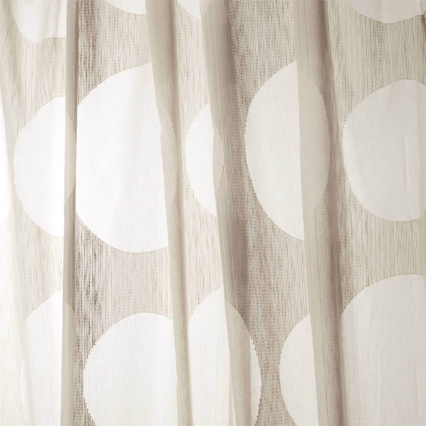 Beige sheer curtain with white spots pattern and soft vertical folds.