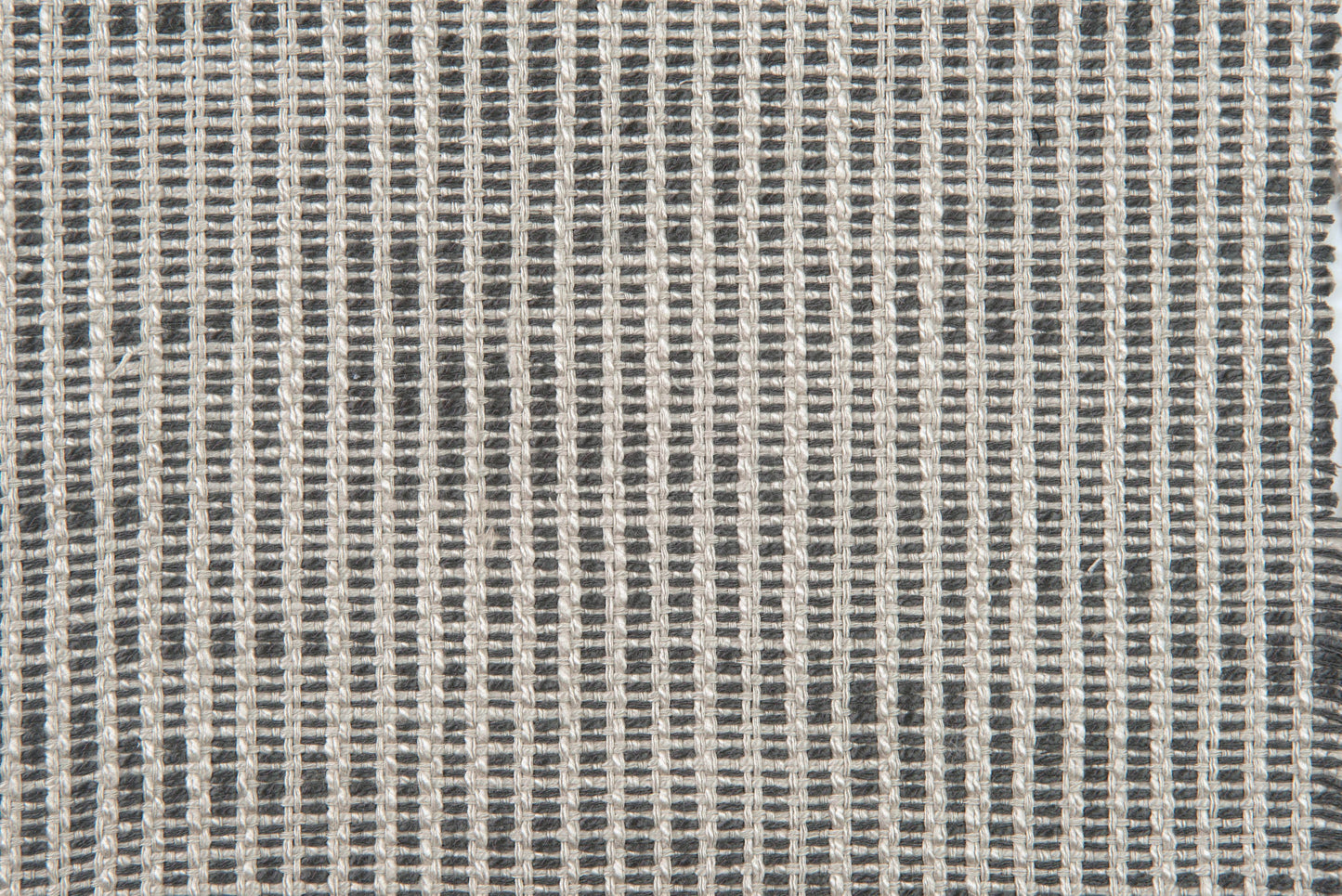 Close-up of charcoal and light gray woven fabric with a tight grid pattern and textured yarns.