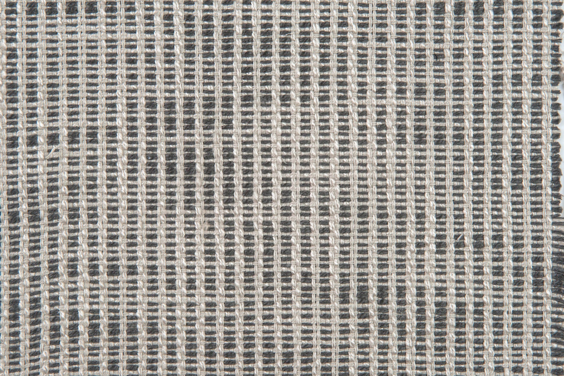 Close-up of charcoal and light gray woven fabric with a tight grid pattern and textured yarns.