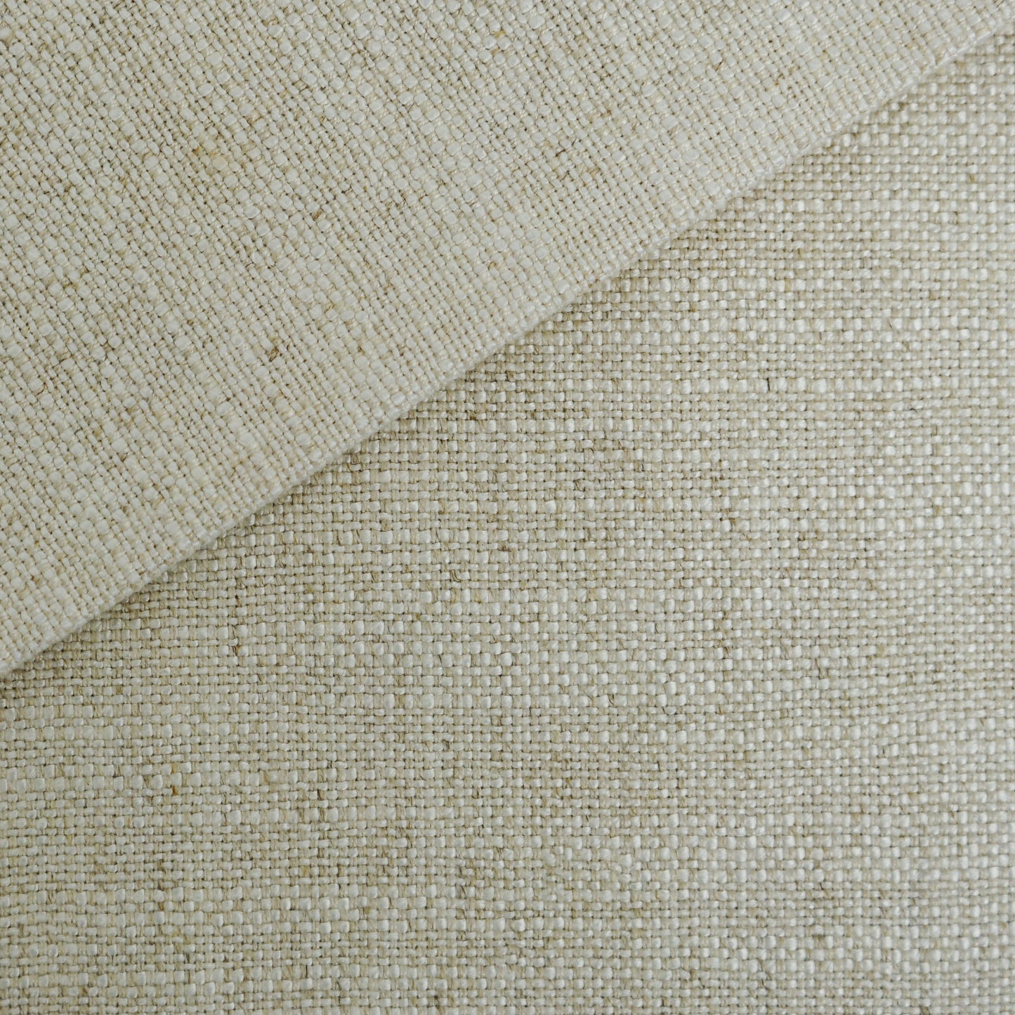 Beige woven fabric close-up with folded corner, natural fiber texture for rustic home decor.