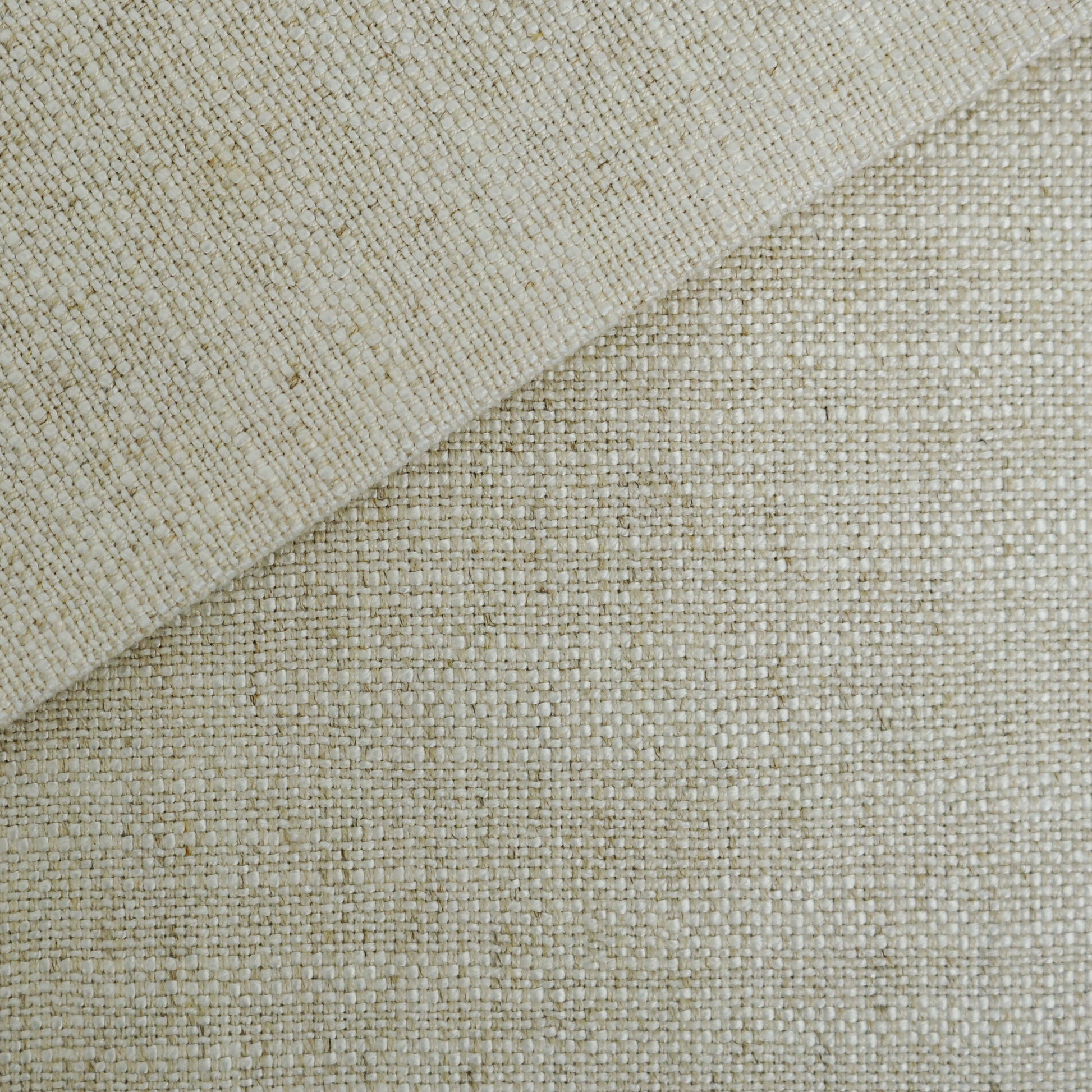 Beige woven fabric close-up with folded corner, natural fiber texture for rustic home decor.