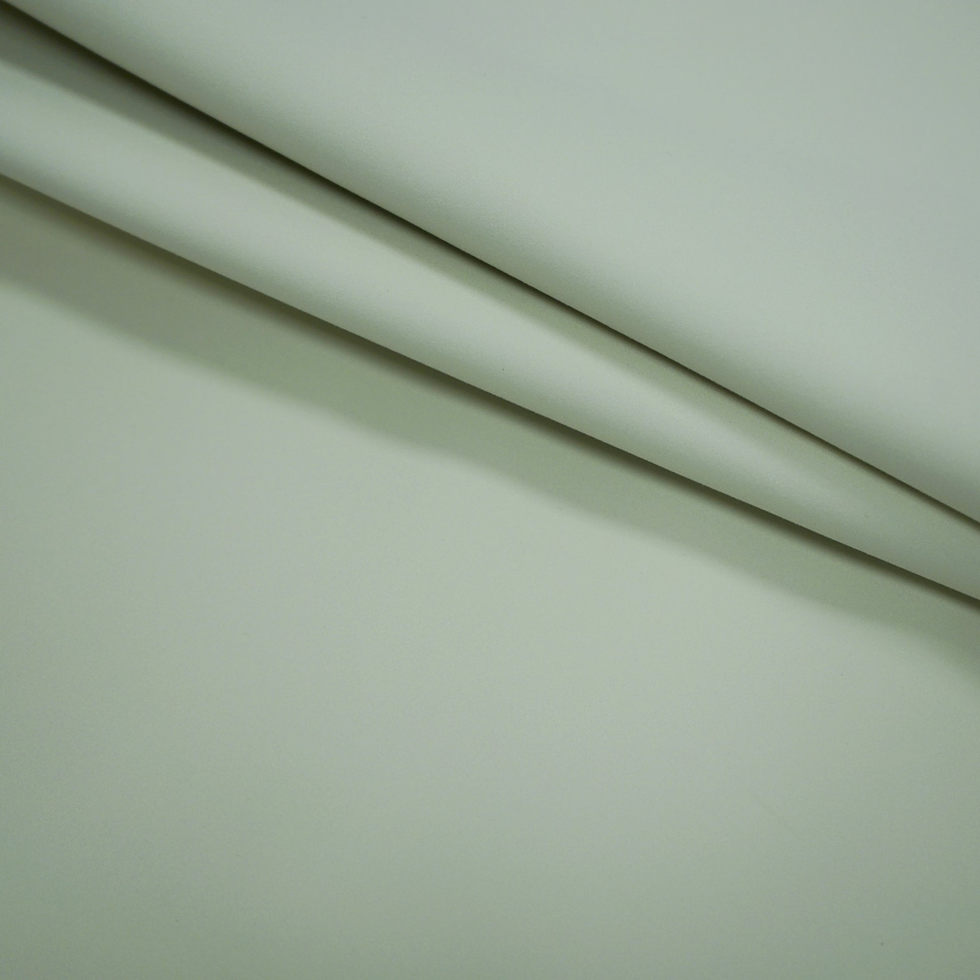 Creme beige fabric folds with a smooth matte finish and soft drape; blackout lining fabric.