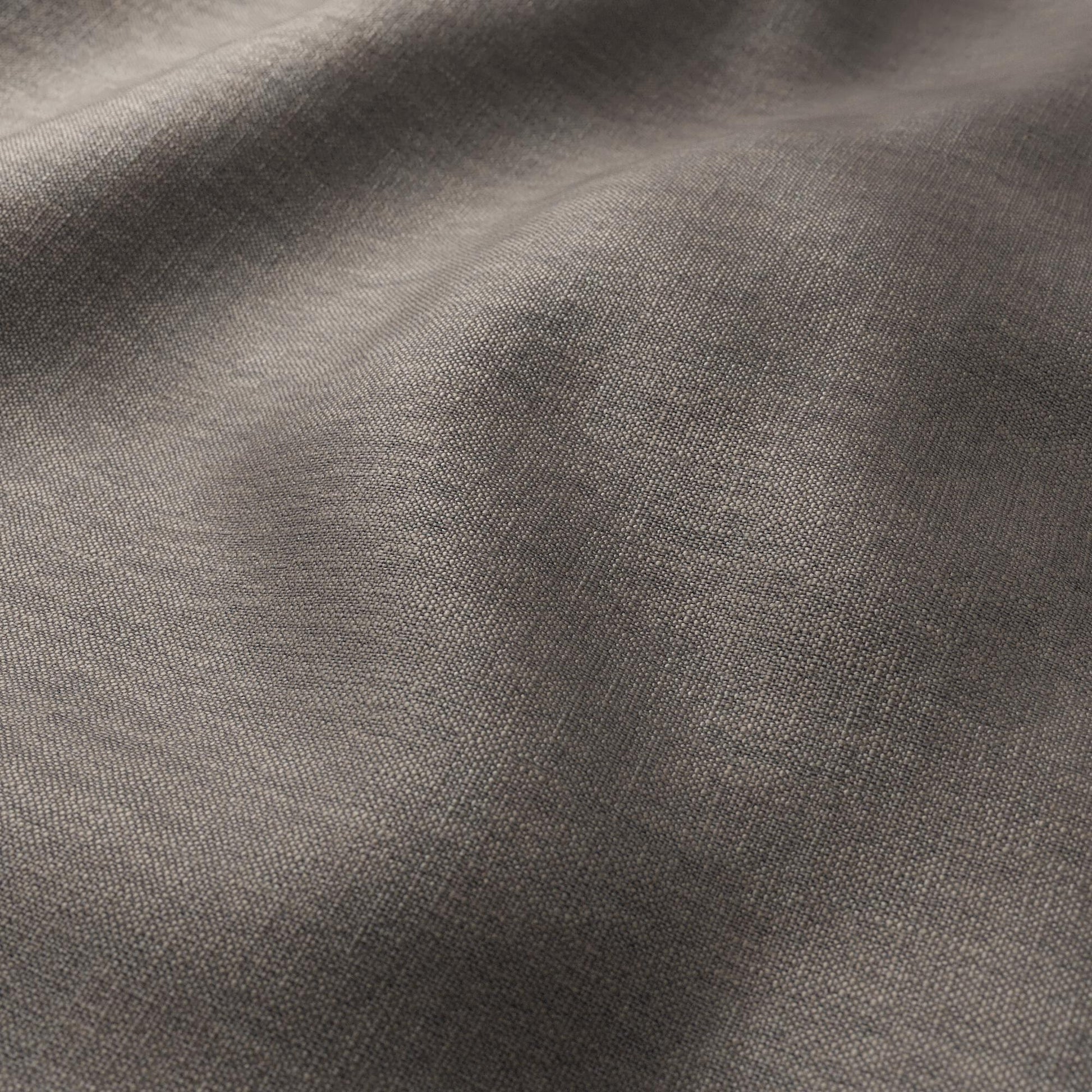 Textured chocolate-brown woven fabric with gentle folds; linen texture, plain weave; versatile for clothing or home decor.