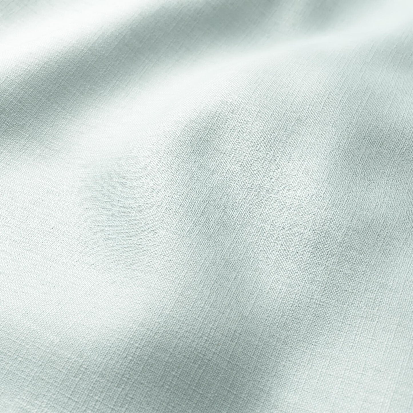 Mint green linen-like fabric close-up with gentle folds and soft texture.