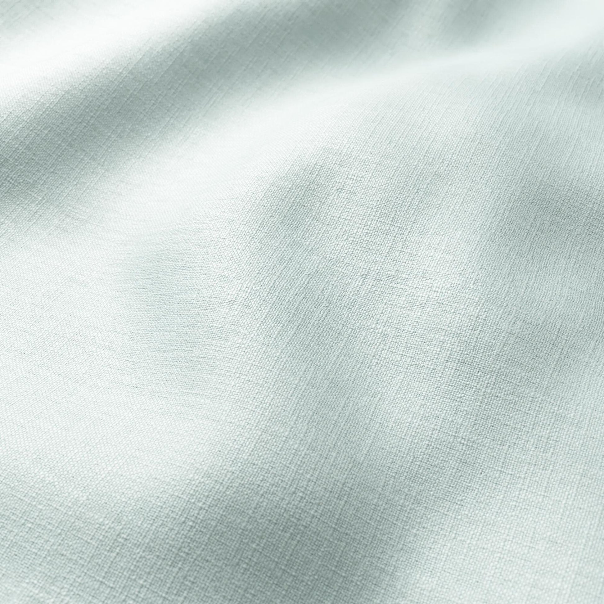 Mint green linen-like fabric close-up with gentle folds and soft texture.