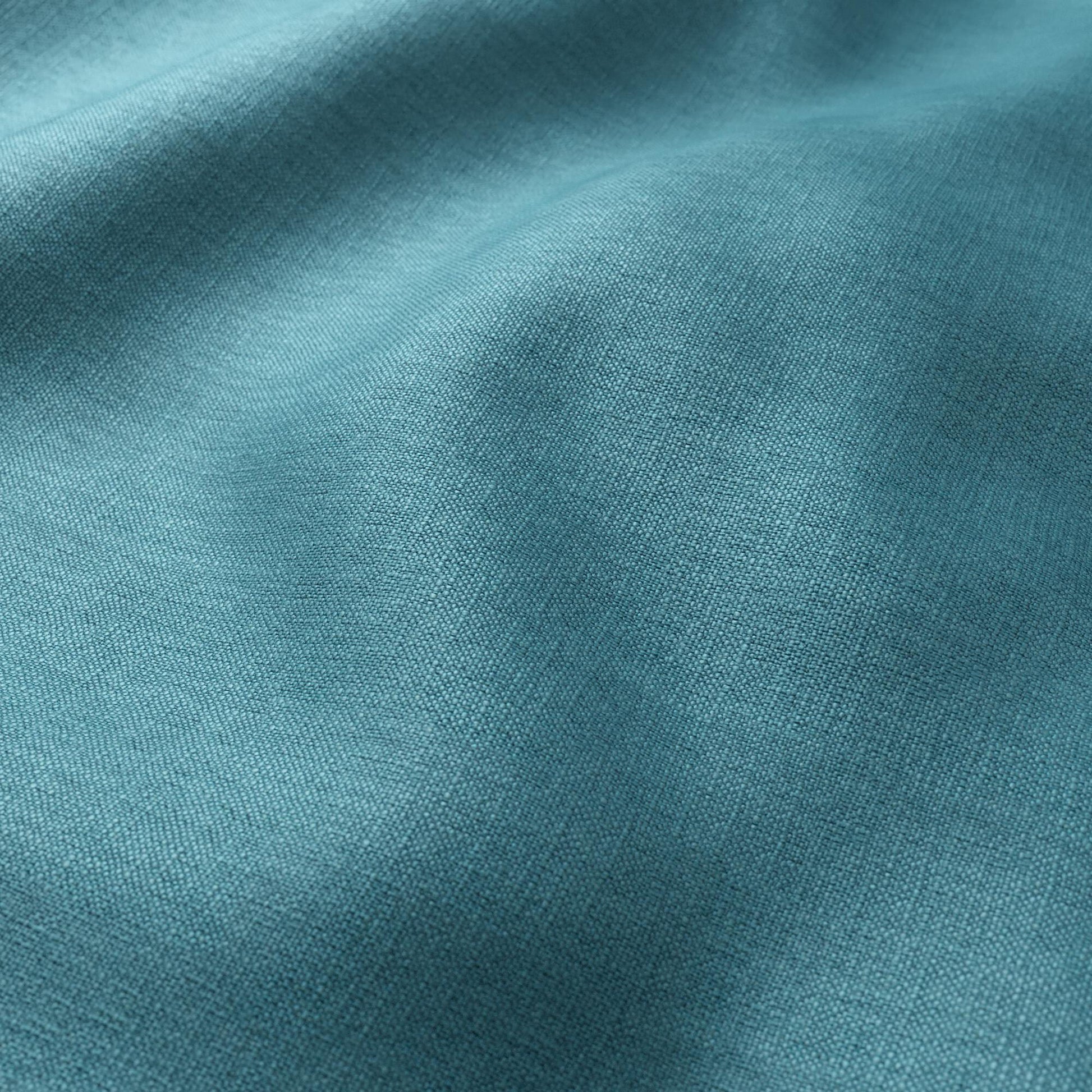 Teal blue linen-like fabric close-up with soft drape and textured weave.
