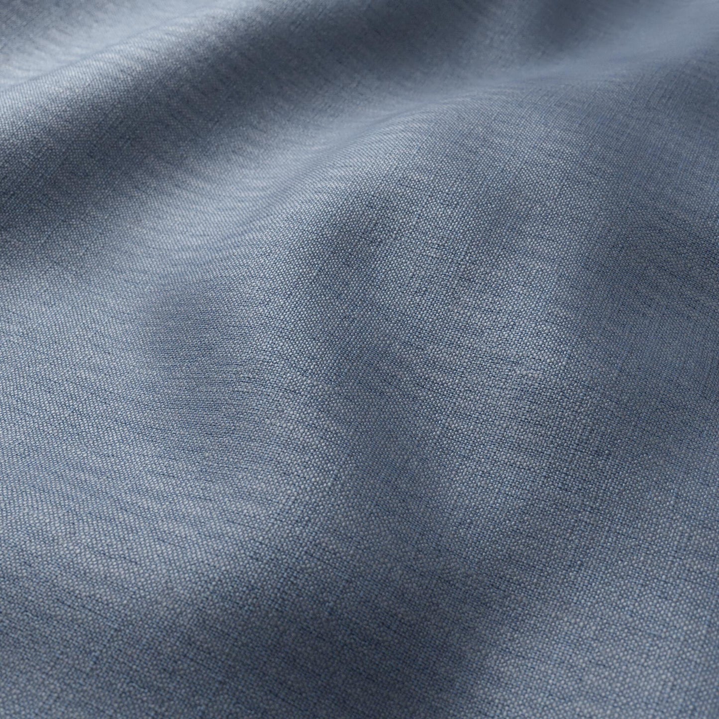 Close-up of light blue woven fabric with linen texture, visible weave and soft drape.