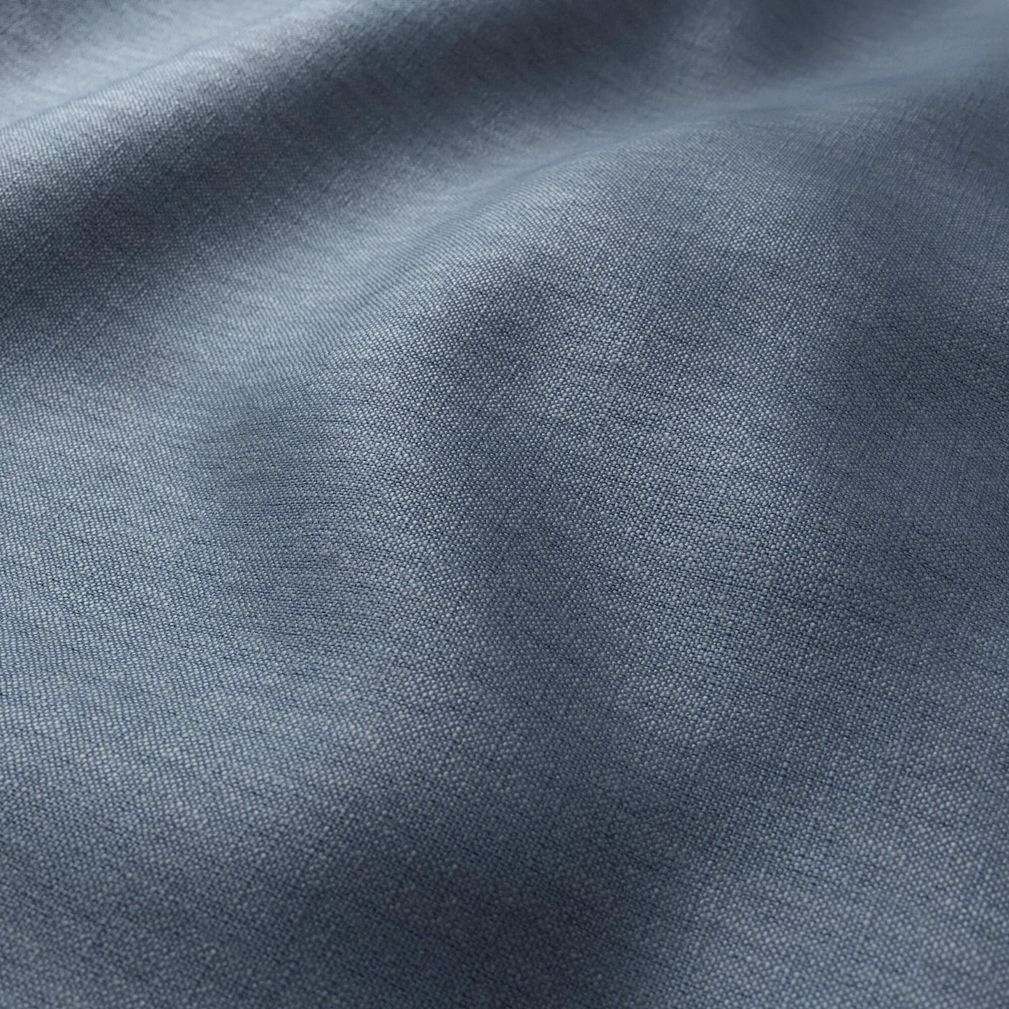 Close-up of light blue fabric with a fine weave and soft draped folds.