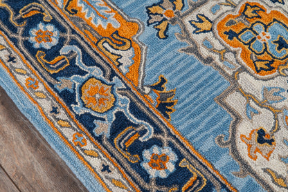 Blue, orange and ivory ornate rug with floral motifs and striped border, on a textured pile, on wood floor.