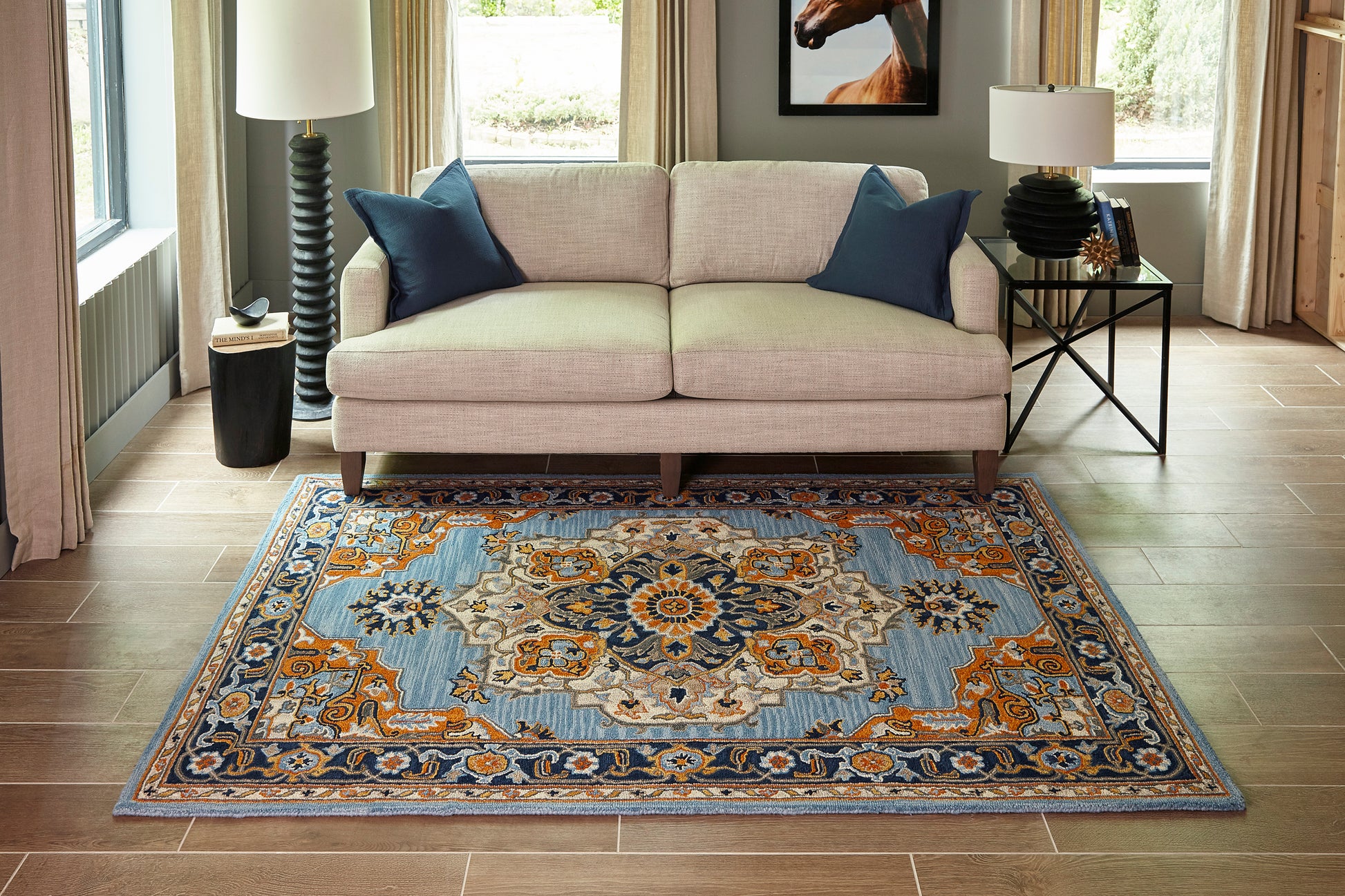 Blue and orange oriental rug with beige and navy accents; 2' x 3' size in a modern living room with wood floors.