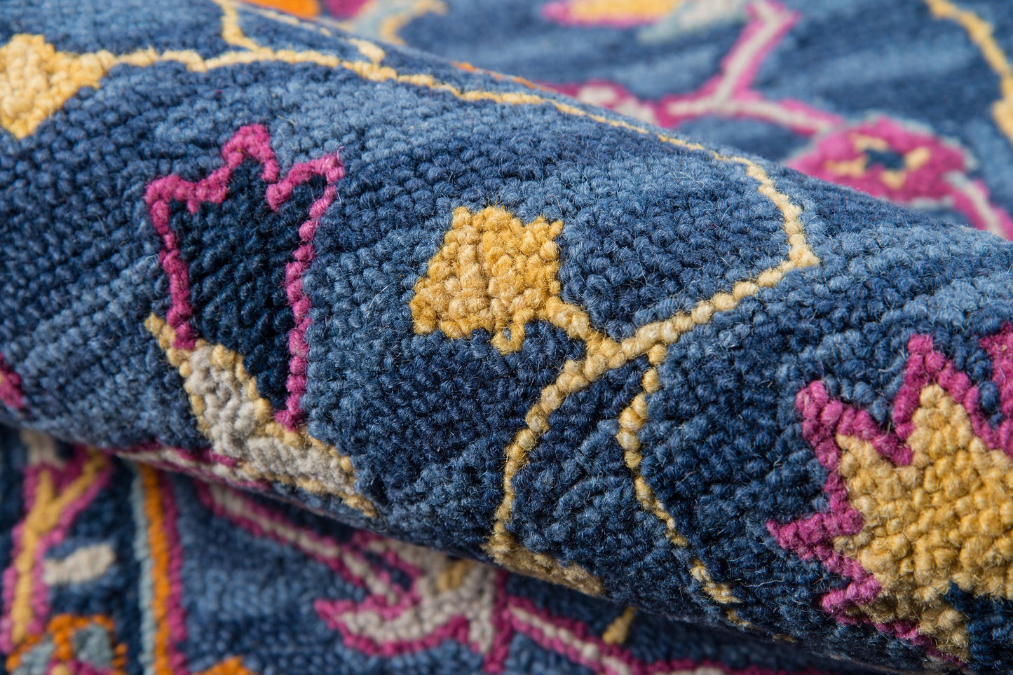 Ibiza blue rug close-up with mustard, pink and beige geometric floral motifs in plush wool pile