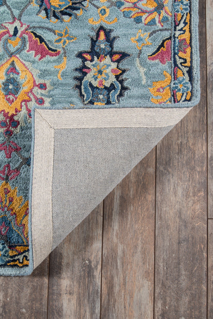 Ibiza blue rug with teal and multicolor floral pattern, bound edge; corner folded to show underside.