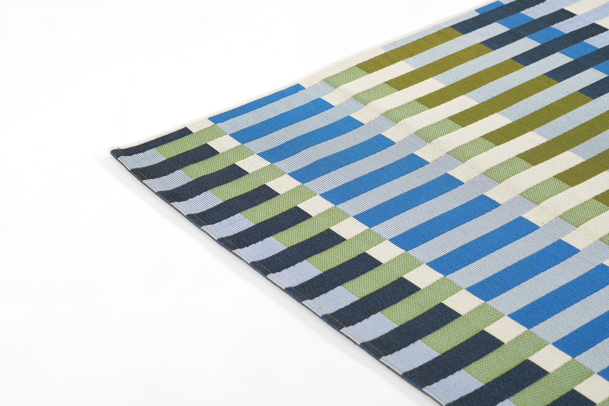 Woven rectangular rug in blue, olive green, cream & gray blocks forming a geometric striped checker pattern; modern rug.