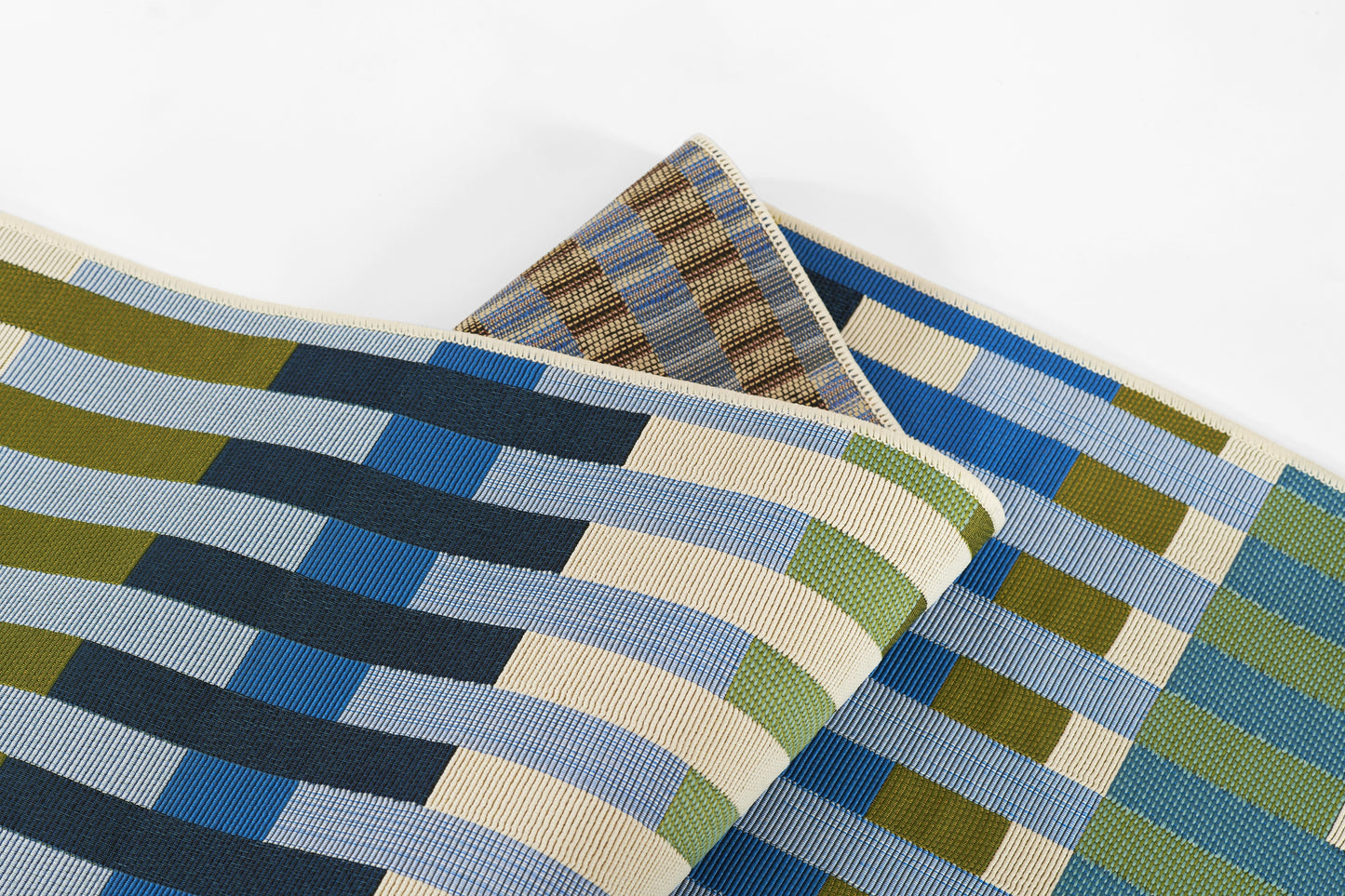 Woven rug with blue, olive and beige striped blocks in a geometric pattern, folded.