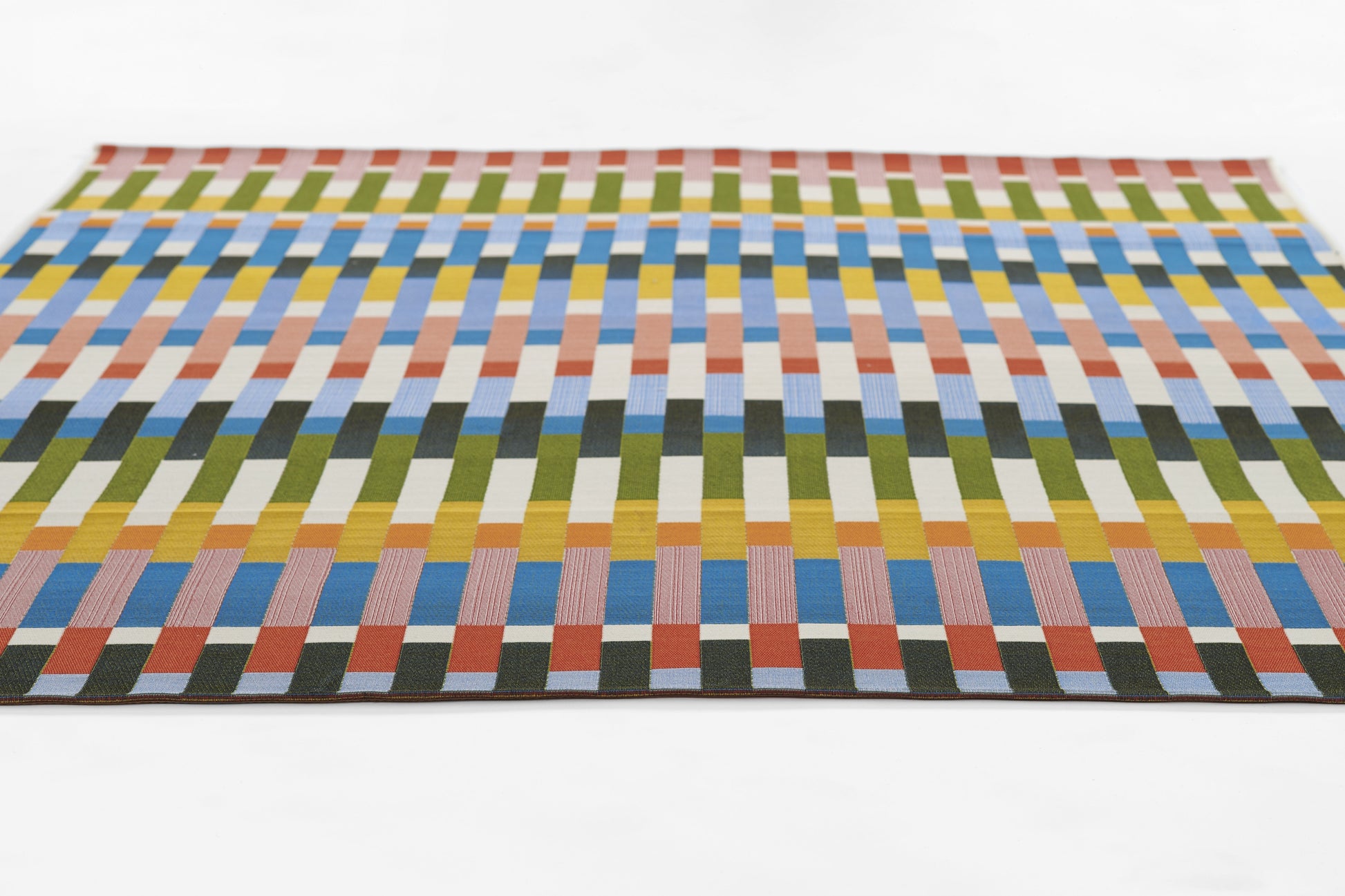 Rectangular woven rug with multicolor vertical blocks in greens, blues, yellows, oranges; modern geometric design.