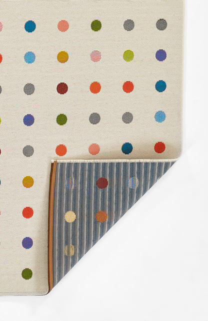 Beige rug with multicolor polka dots; folded corner reveals blue striped underside; 8' x 10'.