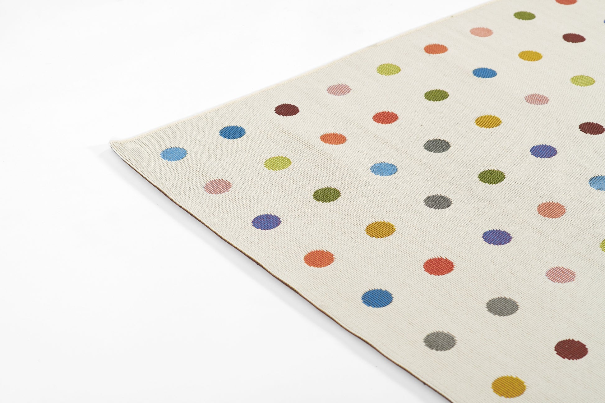 Beige woven rug with multicolored polka dots in blue, red, yellow, green and pink; rectangular, cozy modern floor decor.