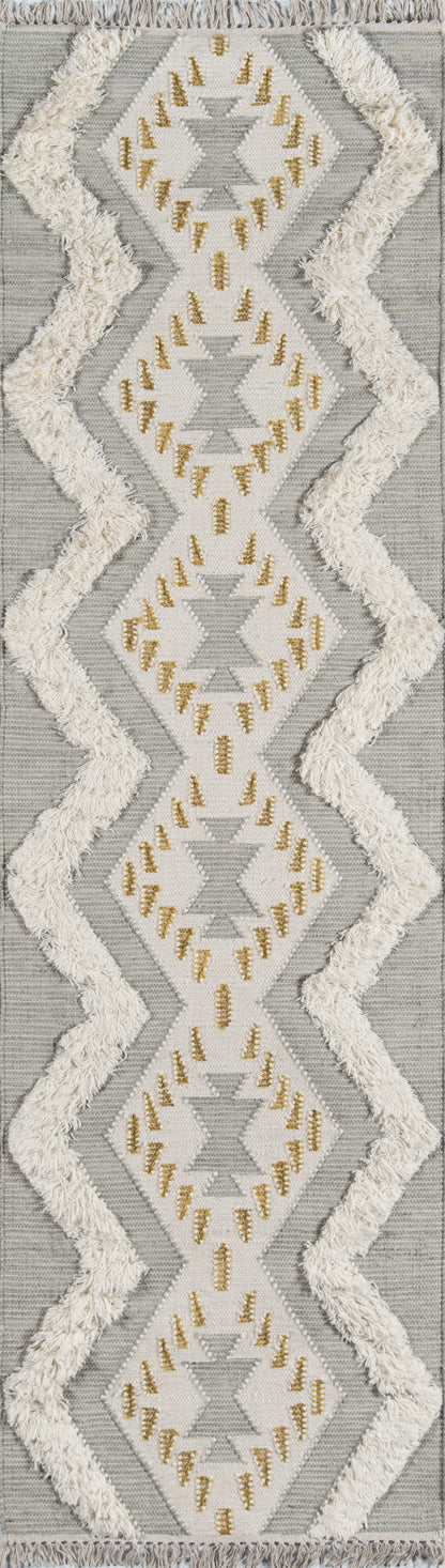 Gray and white geometric area rug with diamond motifs, gold embroidery, and chunky white fringe.