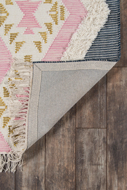 Pink, white and gold geometric rug with fringe, folded to show beige underside on wooden floor.