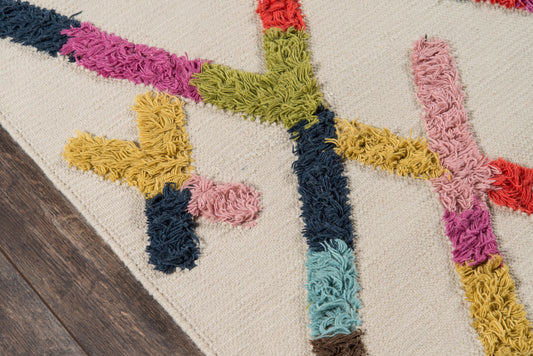 Colorful shaggy rug with thick yarn stripes in navy, mustard, pink, teal, green & red on beige background.