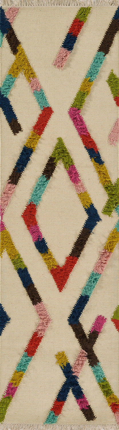 Beige woven rug with bold multicolored shaggy zigzag stripes forming X shapes; pink, blue, green and yellow fringe.