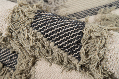 Beige woven rug with black striped band and chunky fringe tassels; textured boho style.