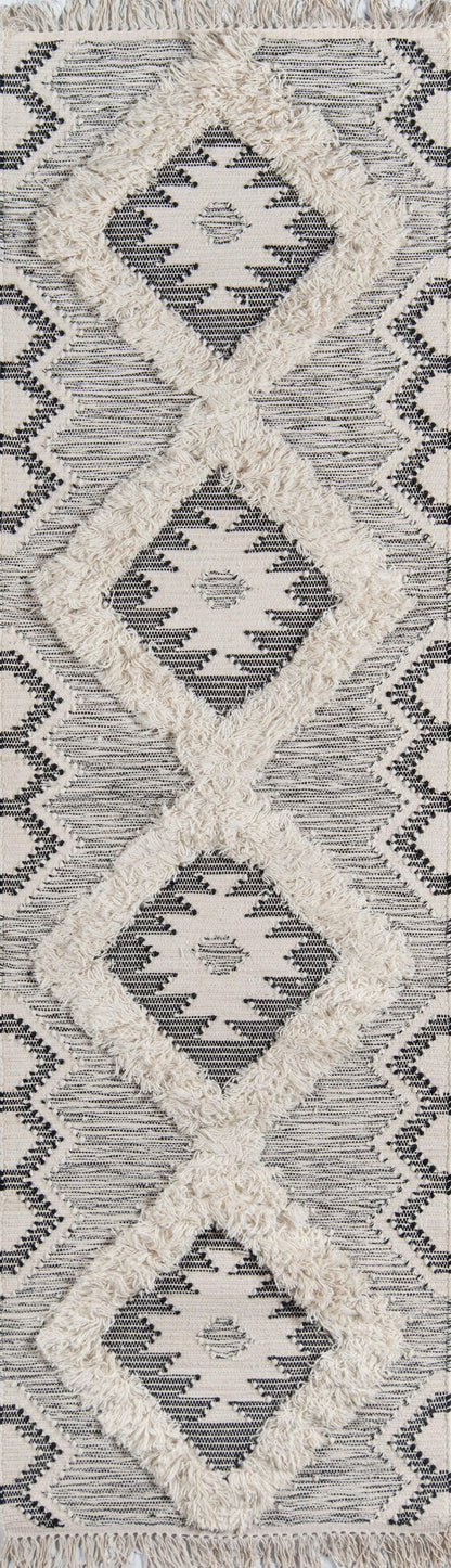 Ivory rug with navy geometric diamond pattern; plush cream shag borders and fringed edges.