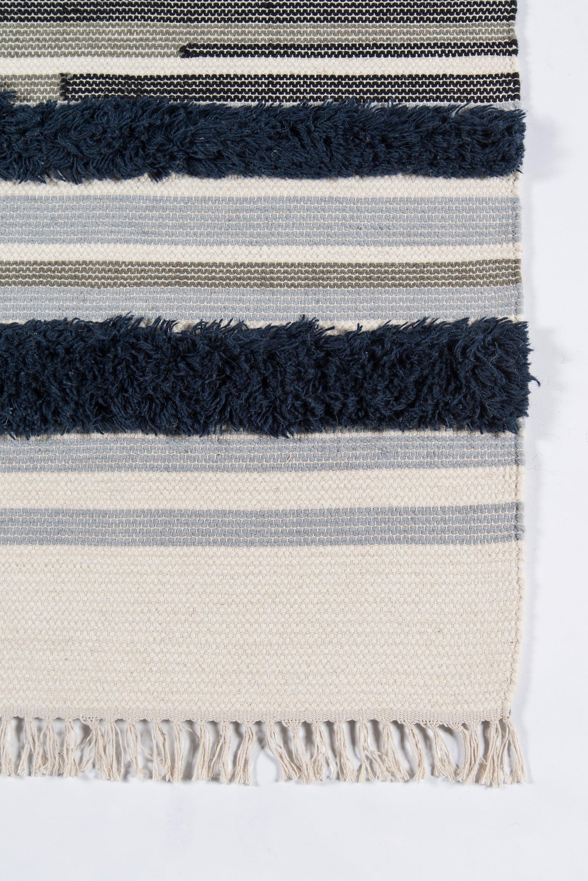 Beige striped woven rug with dark navy fringe and tassel bottom edge.