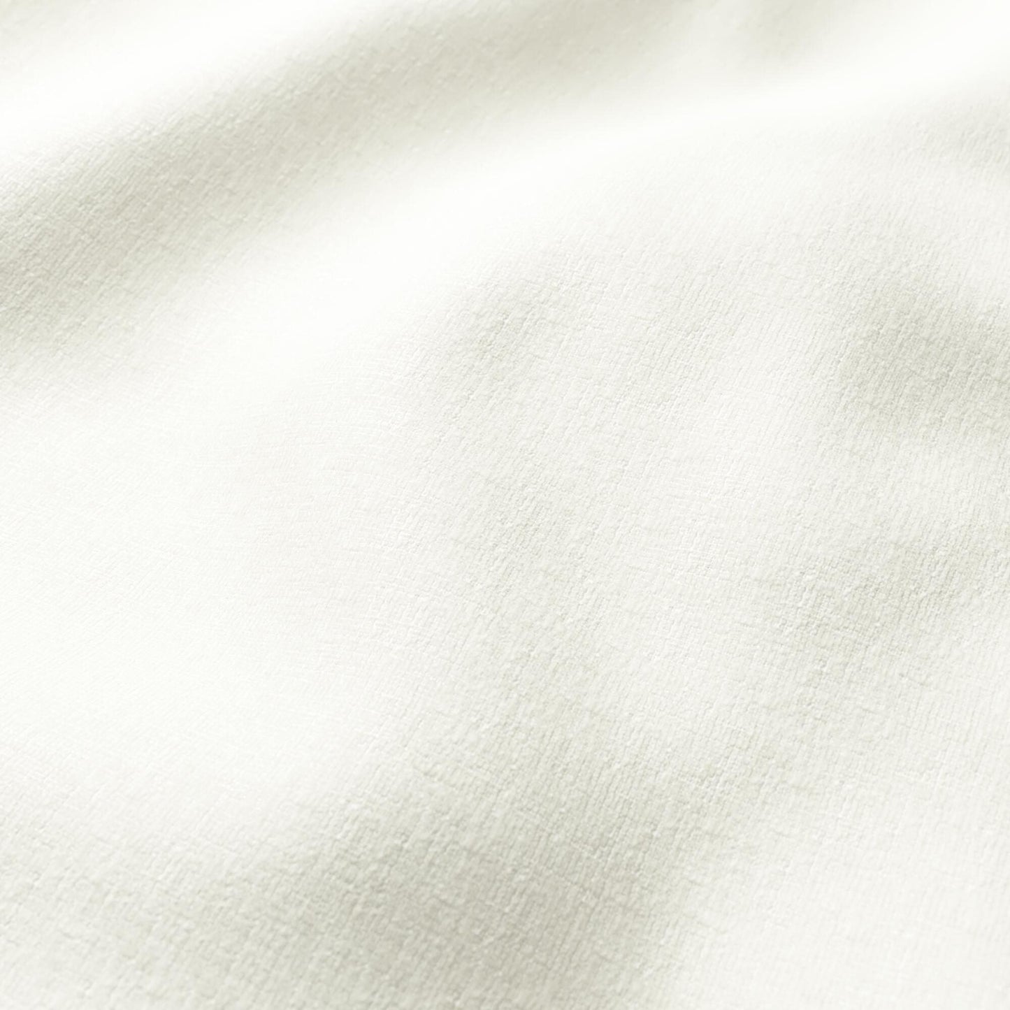 Cream-colored fabric close-up with soft nap and gentle folds.
