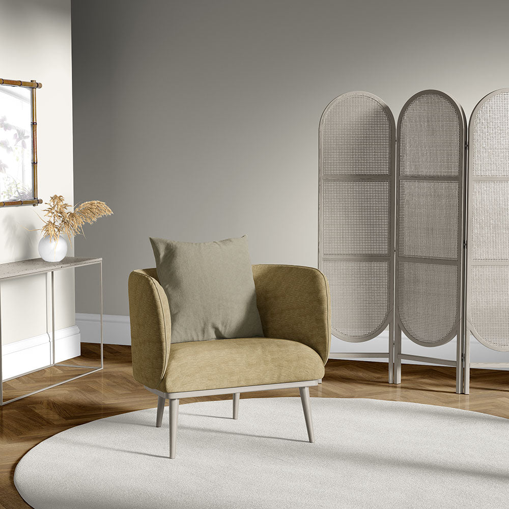 Mid-century tan lounge chair with slim metal legs and beige cushion in a neutral living room with a woven divider.